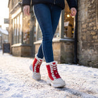 Woman walking down a snowy high street in the Red women's winter boots