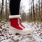Woman wearing the platform snow boots in Red on a snowy woodland path