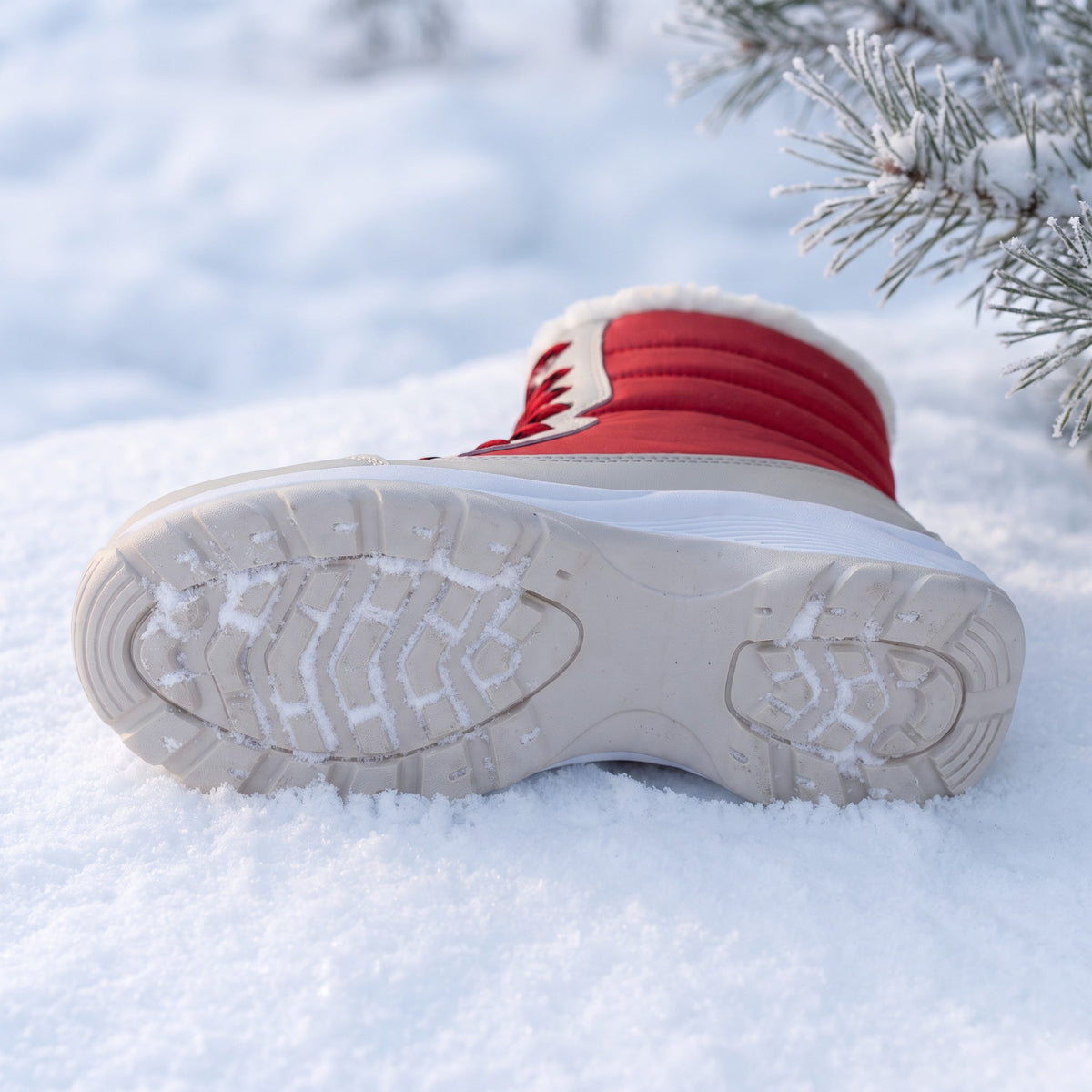 Lugged rubber outsole of the platform snow boots with packed snow in the tread