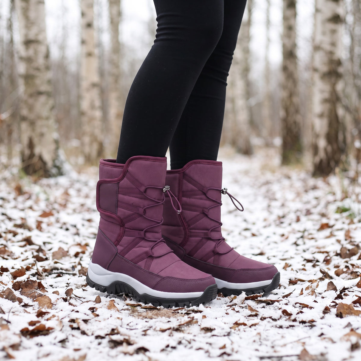 Plum winter boots for women worn with leggings on a snowy woodland path