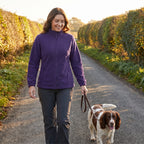 Woman walking her spaniel down a country lane in the Dark Purple women's fleece jacket