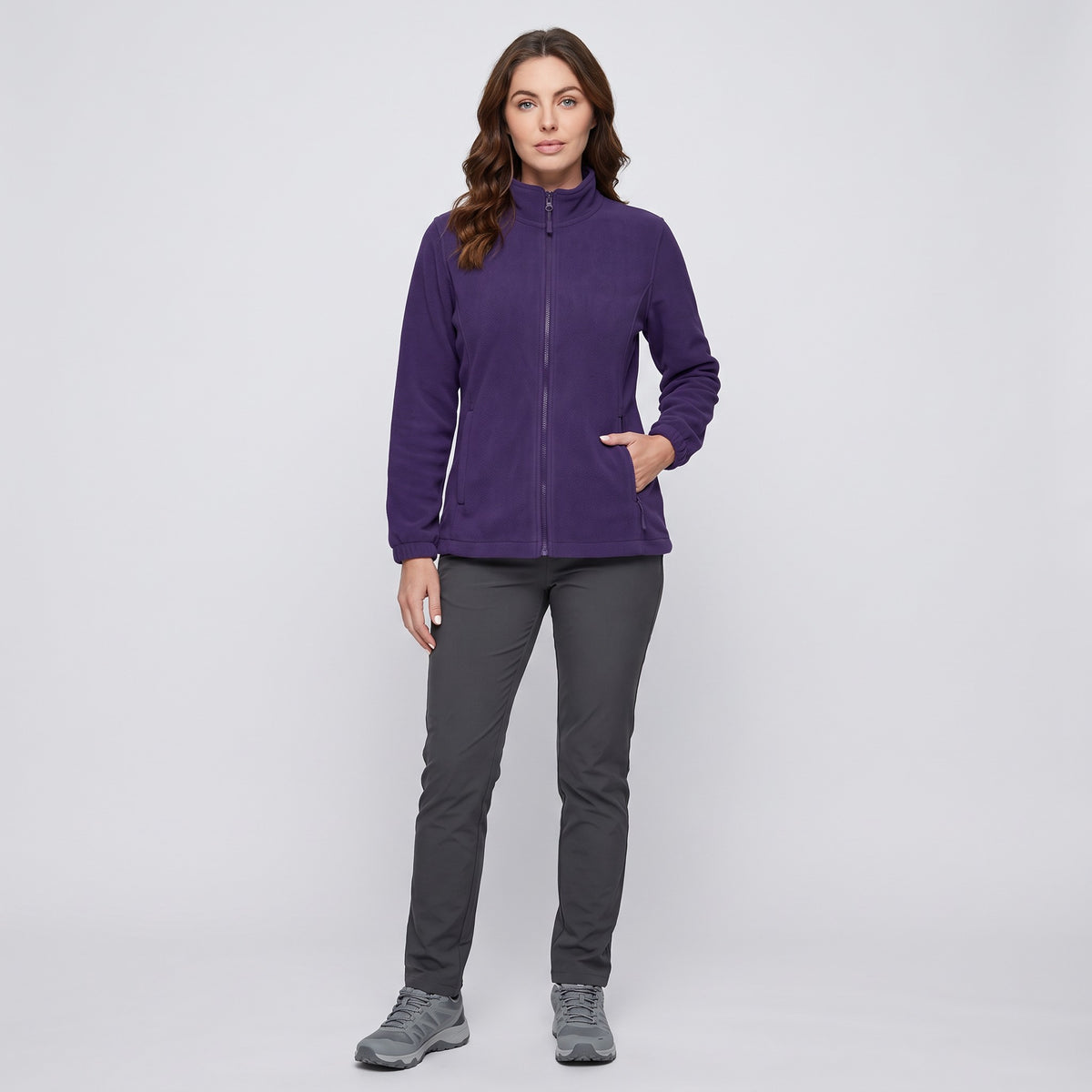 Woman wearing the Dark Purple full zip fleece with walking trousers and trail shoes, full length