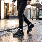 Man walking along a wet winter high street in the Black fur lined winter trainers