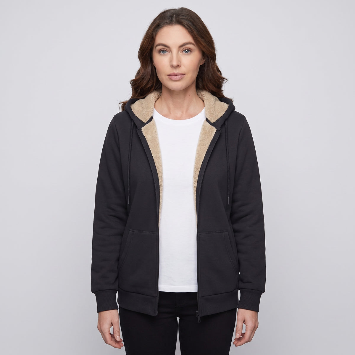 Woman wearing the Black sherpa lined zip up hoodie open over a white T-shirt, front view