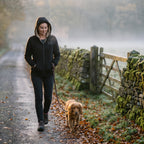 Woman walking a spaniel on a misty autumn lane in the Black sherpa zip up hoodie, hood up
