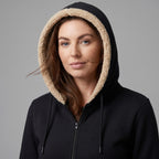 Woman wearing the sherpa lined hood up, drawcords hanging at the front