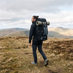Man walking a Brecon Beacons ridge with the Terrabound 70L hiking rucksack packed and a sleeping mat strapped on
