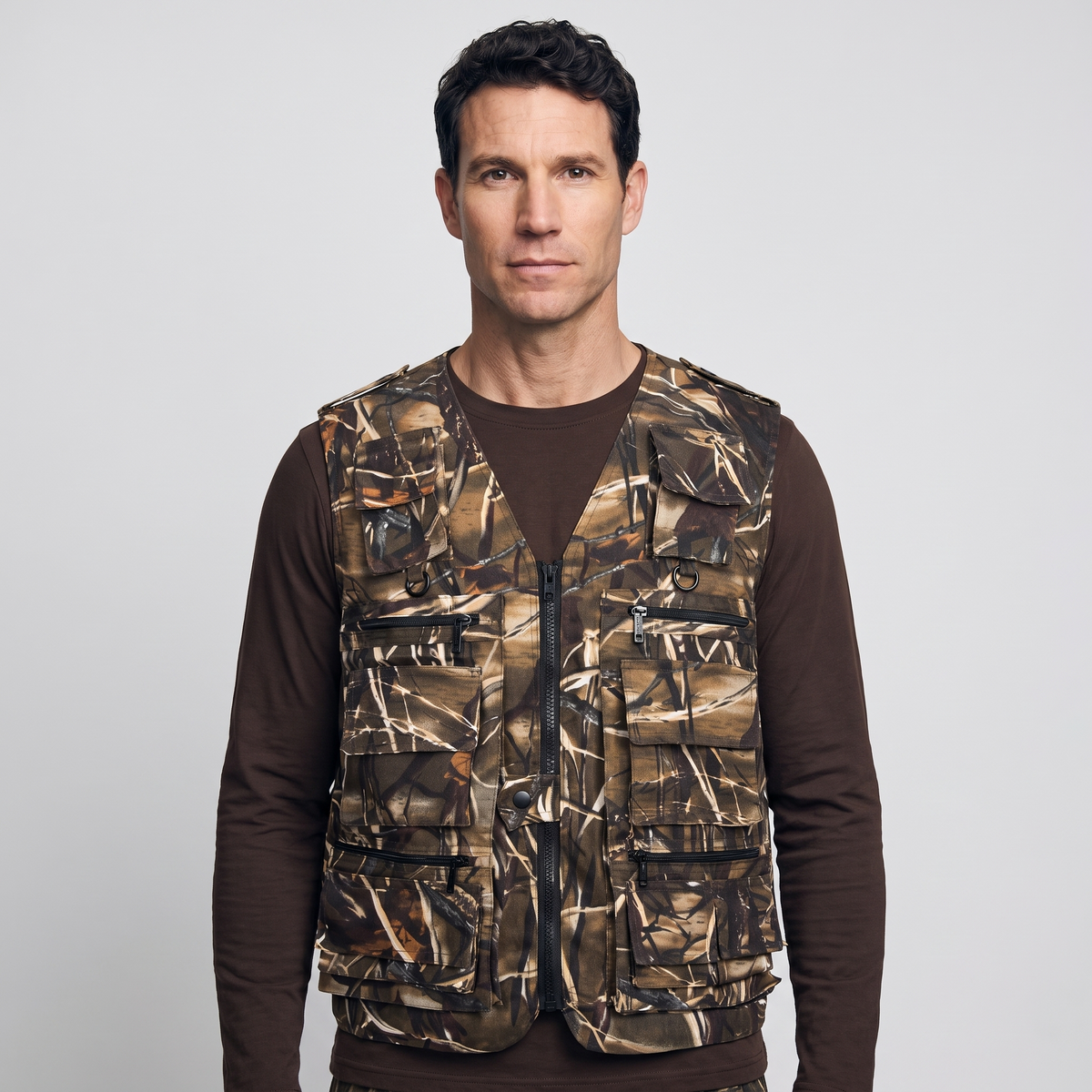 Front view of the camo utility vest worn, showing zip and flap pockets