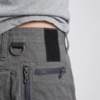 Waistband close-up with metal D-ring, hook-and-loop panel and zipped hip pocket