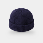 Navy fisherman beanie from above, showing the rib gathering at the crown and the turned cuff