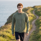 Man wearing the army green sun hoodie on a coastal path at golden hour