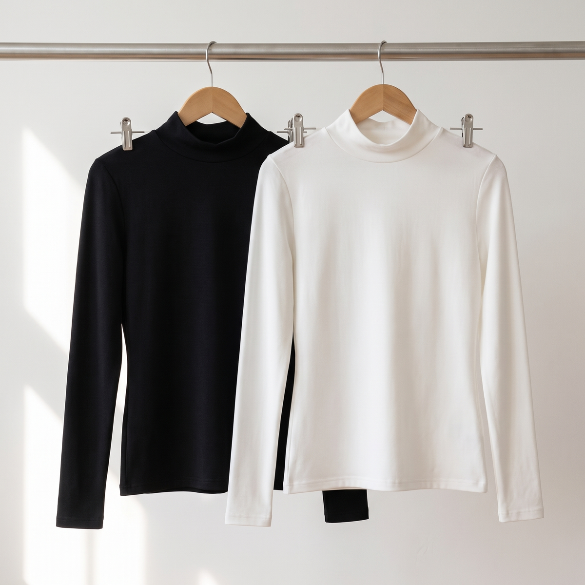Women's thermal base layer tops in black and white on a clothes rail