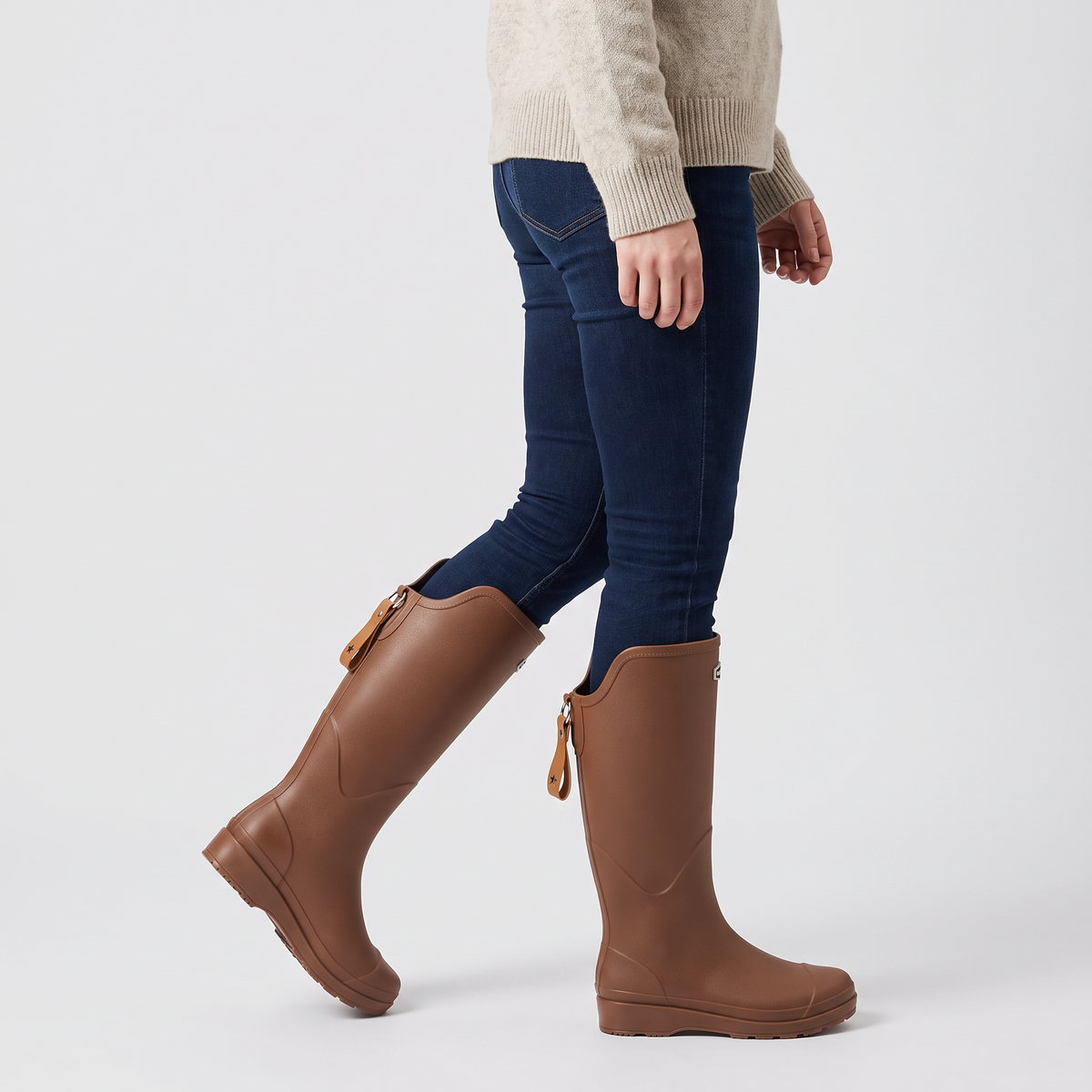 Women's knee high wellies in Brown worn mid-step, three-quarter side view