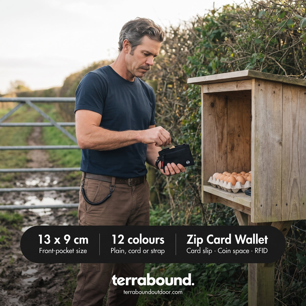 Walker taking coins from the zip card holder at a farm honesty box, cord clipped to his belt loop