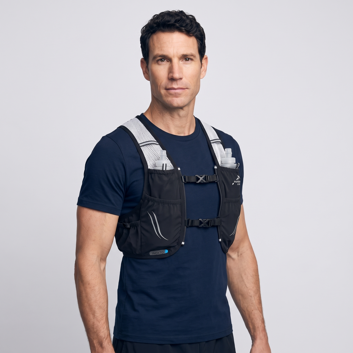 Man wearing the Terrabound trail running vest in Black with both chest straps clipped and soft flasks in the chest pockets