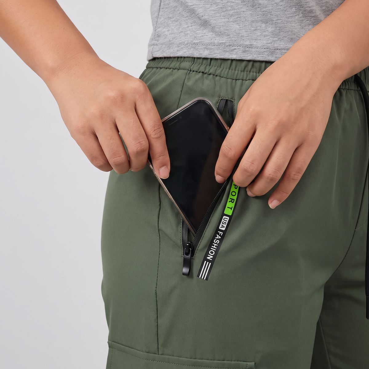 Hand sliding a phone into the zip hip pocket of the Terrabound women's cargo trousers
