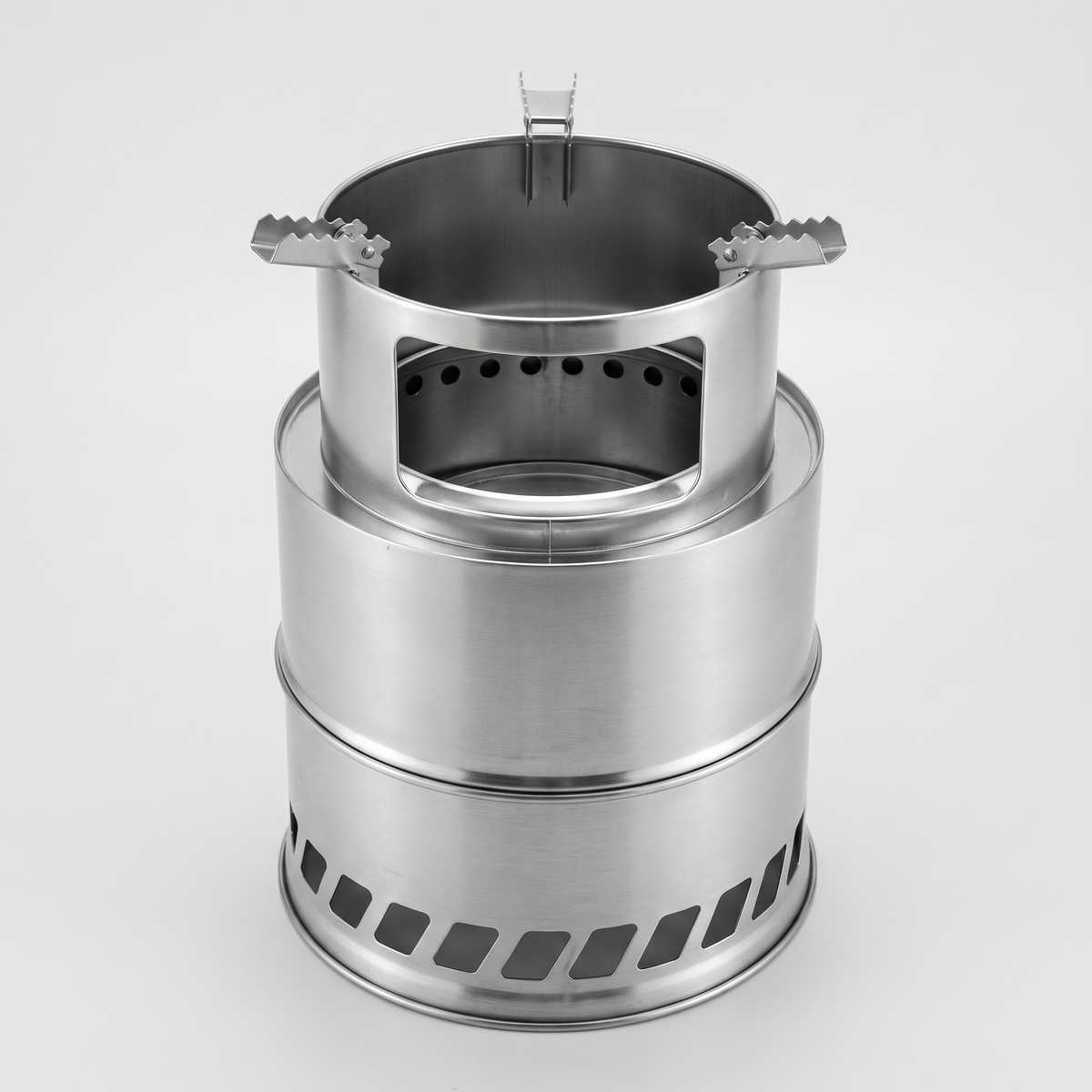 Large wood burning camping stove in stainless steel, with a tall pot support, a fuel window and three toothed pot arms